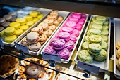 Various different coloured macaroons in a display cabinet