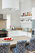 Bar stools with blue and white patterned upholstery at breakfast bar in modern kitchen area