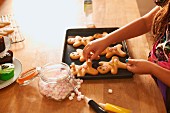 A girl decorating gingerbread men for Halloween