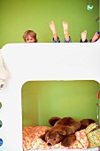 Children on bunk beds against green-painted wall