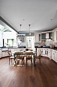 Large kitchen with fitted cupboards and rustic, country-house-style dining set