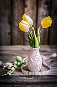 Yellow tulips in small ceramic vase