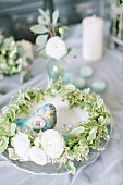 Wreath of Ficus leaves and ranunculus with bird ornament