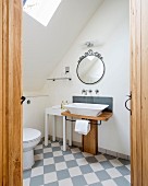 Custom wooden washstand with countertop sink and white and pale grey chequered floor tiles in bathroom seen through open door