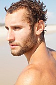 Portrait von jungem Mann am Strand