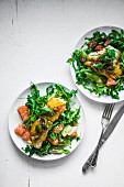 Grilled tilapia with a rocket salad and tomatoes
