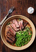 Sliced beef steak with peas and rosemary