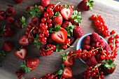 Verschiedene Beeren in Schalen und daneben