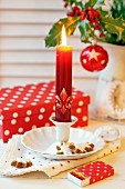 Advent arrangement of candlestick, cinnamon biscuits, matchbox with festive wrapping and gift box