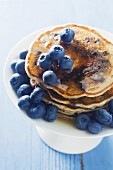 Pancakes with blueberries and honey on a cake stand