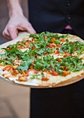 Tarte flambée with rocket, cherry tomatoes, chanterelle mushrooms and sour cream