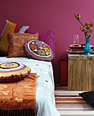 Indian summer in bedroom: bed decorated with colourful chenille and crocheted scatter cushions