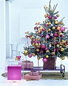 Geschmückter Christbaum dekoriert mit goldenen Paradiesvögeln und Kugeln in Pink, Gold und Silber
