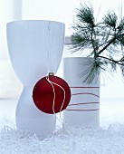 Elegant white vase decorated with red Christmas tree bauble
