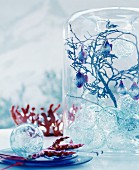 Fairy-tale Christmas arrangement of glass baubles, twigs and fish-shaped baubles in glass vase