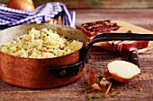 Bavarian coleslaw with onions and bacon in a copper pot