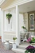 Veranda eines Schwedenhauses mit Blumen und Vorhängen