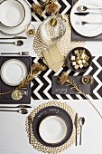 Festively set table in black, white and gold (top view)