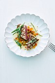 Grilled tuna fish fillet on a bed of vegetables