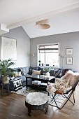 Ethnic accessories and grey corner sofa in living room