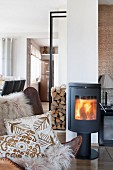 Sheepskin rug and ethnic cushions on leather armchair in front of log burner
