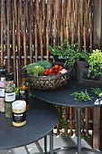 Spices, herbs and vegetables on two round, black side tables