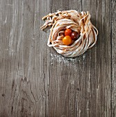 Homemade tomato pasta and fresh cherry tomatoes on a wooden surface