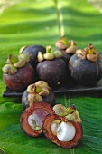 Mangosteens on a place and on a banana leaf