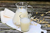 Oat milk in a glass and a jug