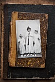 Photo of girls dressed for St Lucy's day celebration on battered, old book