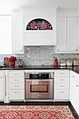 Traditional patterned rug in modern, white country-house kitchen decorated for Advent