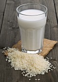 A glass of rice milk behind a pile of rice