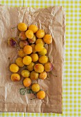 Fresh yellow plums on a paper bag (seen from above)