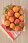 Fresh apricots in a wooden basket (seen from above)