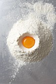 Egg yolks in heap of flour