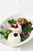 Three different panna cottas with berries and chocolate