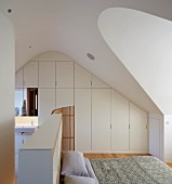 Schlafzimmer im Dachgeschoss mit weißem Einbauschrank und Bad Ensuite im Designerstil