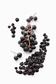 Fresh and dried aronia berries on a wooden surface