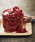 A jar of redcurrant jam with almonds