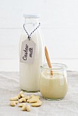A jar of cashew nut mousse and cashew nut milk in a glass bottle
