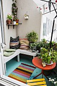Cushions on wooden bench and potted plants on balcony