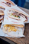 Various flatbread sandwiches wrapped in paper