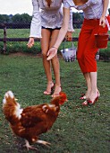 Two woman feeding hens