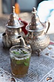 Peppermint tea in silver pots and a glass