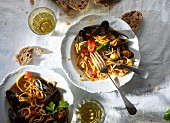 Spaghetti with mussels, white wine and bread (seen from above)