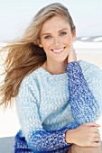 Young woman wearing angora sweater in shades of blue on beach