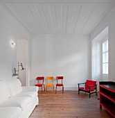 White living room with colourful retro chairs and armchair