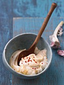 Aioli in a bowl with a wooden spoon