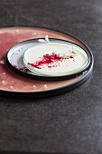 Pelargonian panna cotta with beetroot powder and edible flowers