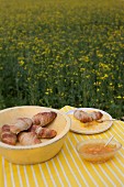 Croissants und Marmelade auf Tisch im Rapsfeld